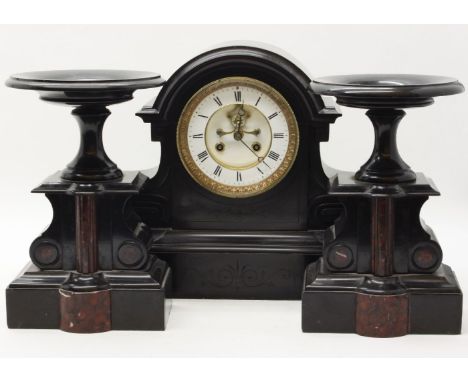 A late Victorian black slate mantel clock, the white dial with black Roman numerals with visible escapement, together with tw