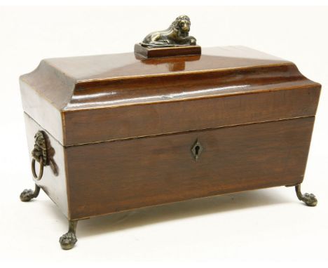 A 19th century inlaid mahogany tea caddy, of sarcophagus form, with a recumbent lion to the lid and a fitted interior, all on