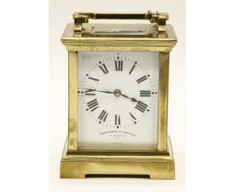 A Shepheard and Co brass carriage clock, with enamel dial and gong strike movement, 12 cm high x 9.5 cm wide