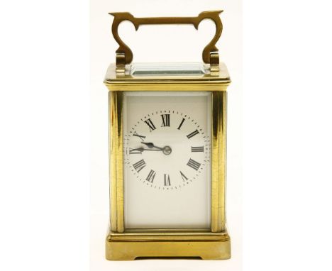 An early 20th century brass and fire glass carriage clock, the white dial with black Roman numerals, the movement striking on