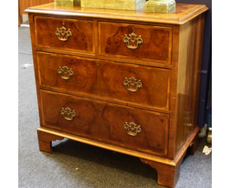 A George III style inlaid walnut chest of drawers, the moulded rectangular top over a series of two short over two long drawe