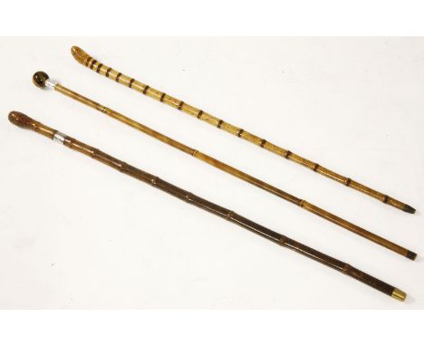 An antique sword stick, the bamboo cane with silver collet and tiger's eye pommel, together with two further bamboo sword sti