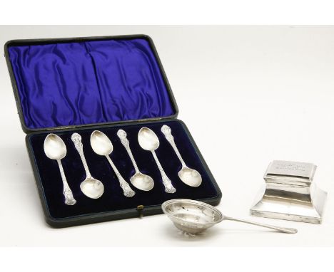 A collection of silver items, to include an inkwell, tea strainer and cased set of teaspoons