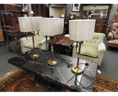 A pair of lacquered brass twin light tables lamps, each 75cm tall, together with a third smaller (a/f) (3)Provenance:  From N