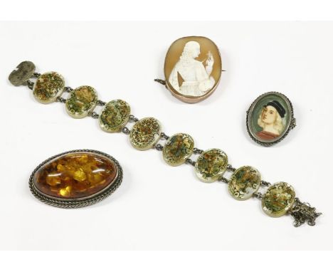 A gold shell cameo brooch, depicting a young maiden with crucifix, mount marked 9ct, an amber cabochon brooch set in a silver