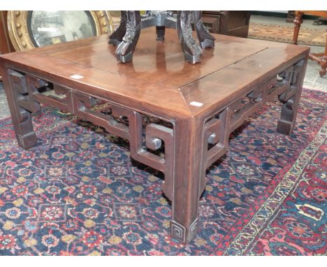 A CHINESE HARDWOOD LOW TABLE WITH PIERCED FRIEZE ON SQUARE LEGS AND CARVED SCROLL FEET.   76 x 76 x H.34cms.