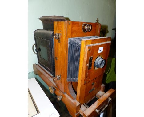 A WOODEN MOUNTED ELLENDALE ENLARGER MAGIC LANTERN WITH DALLMEYER LENS, NOW ELECTRICALLY LIT. H 40.5 x W 55.5cms.as with all e