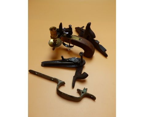 A BAG OF TWO PERCUSSION MUSKET LOCKS AND A BRASS TRIGGER GUARD TOGETHER WITH A REPRO BRASS FLINTLOCK TINDER LIGHTER.