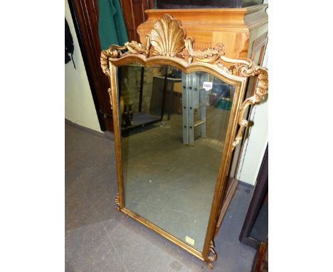 A VINTAGE VICTORIAN STYLE RECTANGULAR MIRROR IN A GILT FRAME THE SERPENTINE TOP CENTRED BY A SHELL BETWEEN FOLIATE SCROLLS. H
