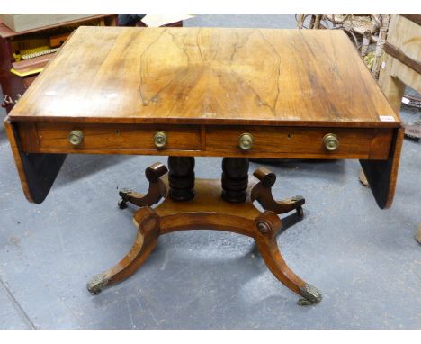 A REGENCY ROSEWOOD SOFA TABLE ON TWIN TURNED SUPPORTS OVER PLATFORM AND QUADRUPED SABRE LEGS WITH FOLIATE BRASS CASTERS. (EXT