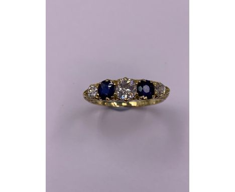 AN EDWARDIAN 18ct GOLD SAPPHIRE AND DIAMOND FIVE STONE CARVED HALF HOOP RING, DATED 1902 BIRMNGHAM. FINGER SIZE R. APPROXIMAT