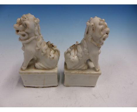 A PAIR OF BLANC DE CHINESE SEATED BUDDHIST LION JOSS STICK HOLDERS.   H 13.5cms.