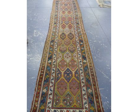 AN ANTIQUE PERSIAN TRIBAL RUNNER.   403 x 96cms.