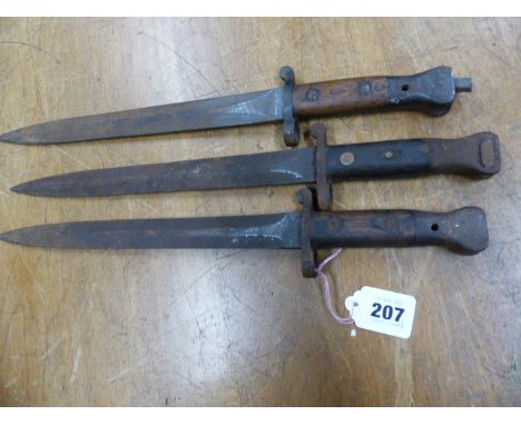 THREE WILKINSON LONDON BAYONETS, ONE BLADE CLEARLY STAMPED ER AND ONE WOODEN HANDLE GRIP STAMPED 05. H 42cms.