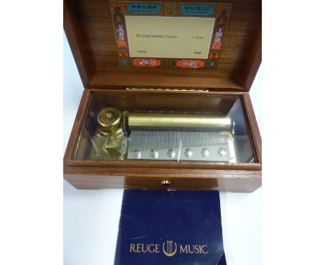 A REUGE MUSIC BOX PLAYING VIVALDI'S FOUR SEASONS ON A COMB.   W 10.5cms. WITH 1991 GUARANTEE, THE WOODEN BOX.   W 20cms.