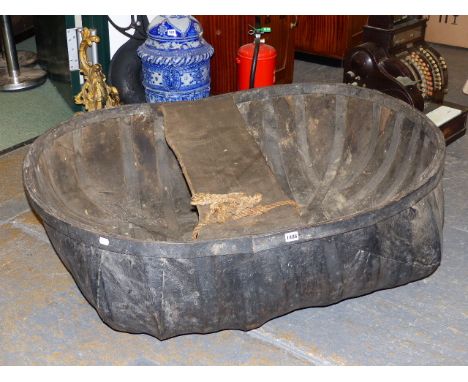 A HAND MADE VINTAGE CORACLE OF TRADITIONAL CONSTRUCTION AND COMPLETE WITH PADDLE.   124 x 95cms.