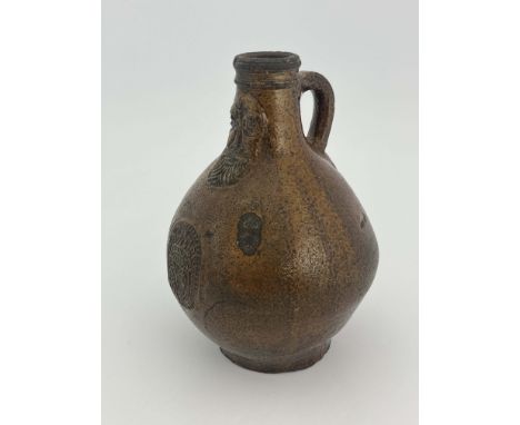 A 17th Century salt-glazed stoneware Bellarmine, loop handle, bearded mask, globular body with crest comprising a shield with