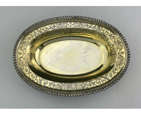 A George III silver gilt basin dish, John Jacob, London 1764, oval broad rimmed form, gadrooned and chased with zoomorphic fo