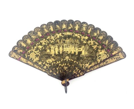 A Chinese Qing Dynasty export lacquer brise fan, early 19th century, 中国扇清朝, the sticks lacquered black and gilt with a centra