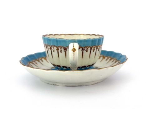 A Worcester enamelled and gilded tea cup and saucer, circa 1775, reeded and fluted, decorated with turquoise borders and gilt