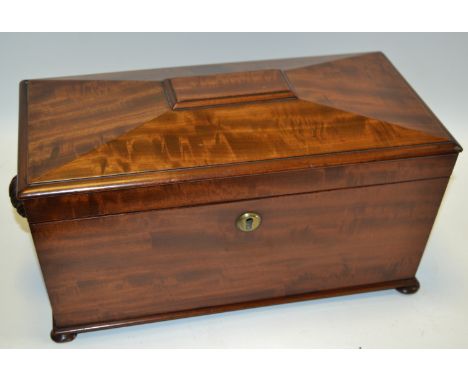 A George IV fiddle-back mahogany sarcophagus tea caddy, hinged cover enclosing a bowl aperture, Bramah type patent lock, bun 