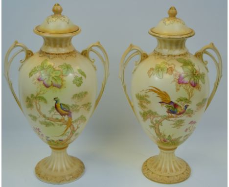 A pair of Crown Ducal blush ivory mantel vases. printed and painted with fanciful bird and foliage,  knop finials, 34cm high,