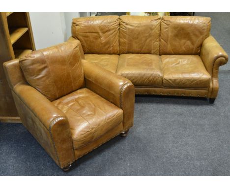 A contemporary studded leather armchair; conforming three seater sofa (2)