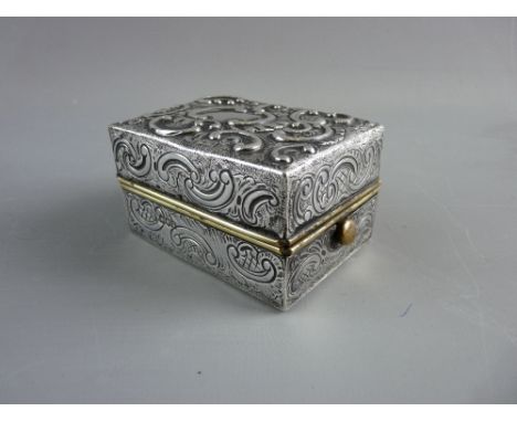 AN UNUSUAL SILVER CASED LIDDED BOX with interior two part fold-out stand, the exterior having all over embossed decoration an