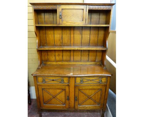 A VINTAGE OAK DRESSER SIDEBOARD, the top with centre cupboard doors and flanking shelves with further shelf below, shaped rac