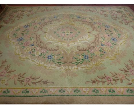 A VINTAGE TUFTED WOOLLEN CARPET having a central floral cartouche and spandrel corners with a single continual border in mute