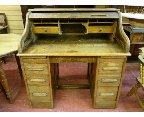 AN EARLY TO MID 20th CENTURY OAK ROLL TOP DESK, typical form with interior top arrangement of pigeonholes and drawers and twi