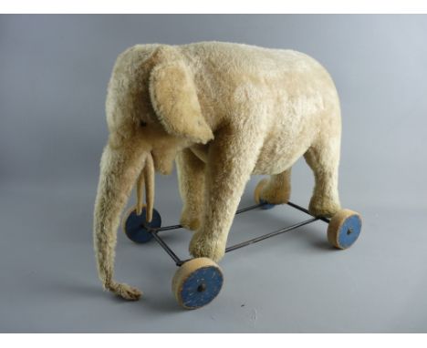 A VINTAGE STEIFF SIT-ON TOY ELEPHANT, ear tag, eyes and ring pull sound box intact but in well loved and play worn condition,