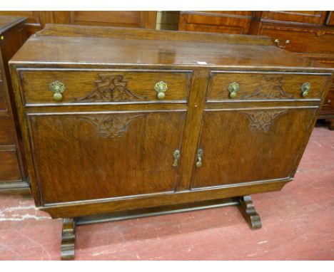 A VINTAGE OAK RAILBACK SIDEBOARD having two drawers and two cupboard doors with blind fret carving, pierced backplates and bu
