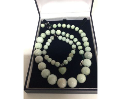A Chinese jade necklace graduating jade beads and a matching bracelet with heart shaped link.