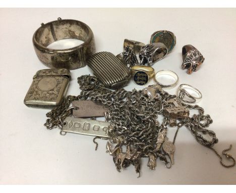 A collection of silver jewellery rings necklaces a charm bracelet a wide silver bangle vesta cases and metal rings.