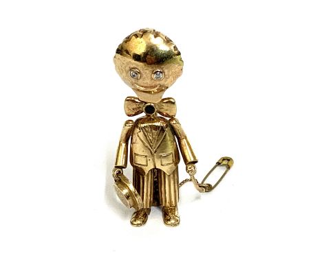 A vintage heavy 9ct gold brooch in the form of a Golly Set with white cut stone eyes and a sapphire within the bow tie. 26.67