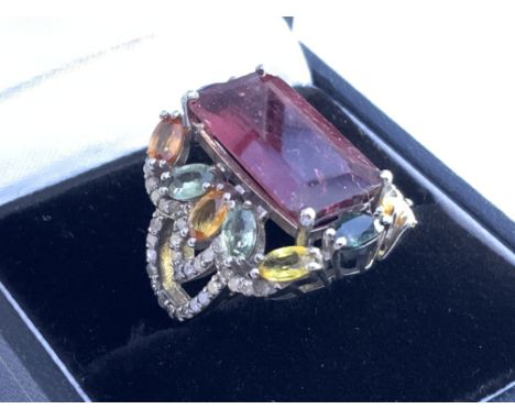 Large silver dress ring set with step cut tourmaline, surrounded by multi coloured sapphires and diamonds, boxed. Tourmaline 