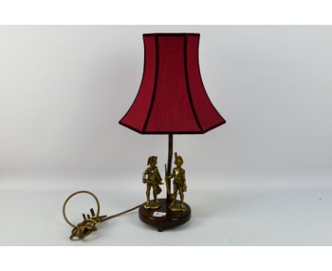 A brass lamp with wooden base. Lamp has 2 x brass military figures attached to its base. Doesn't come with a bulb. 54 cm (h).