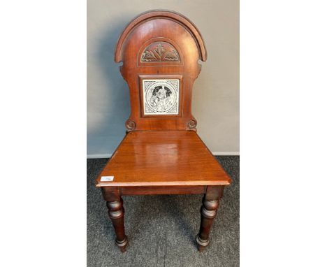 19th century hall chair, the shaped back with carved detail and fitted with a Minton's tile to the centre, raised on turned l