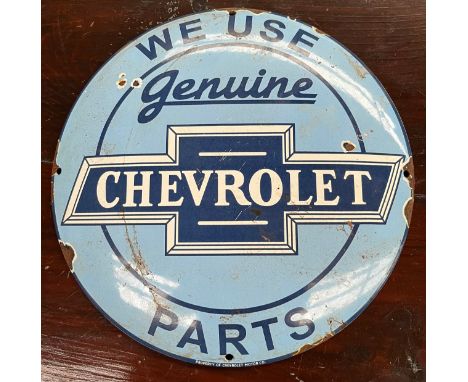 Vintage Chevrolet enamel car advertising sign. 'We Use Genuine Chevrolet Part' produced by Chevrolet Motor Co. Circular conve
