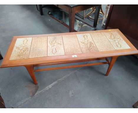 Mid century teak coffee table with tile top and fitted magazine rack. 