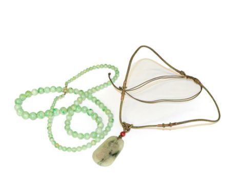 A graduated jade bead necklace, length 73cm, and a jade type pendant on cord necklace.  The jade beads measure 3.81mm - 9.89m