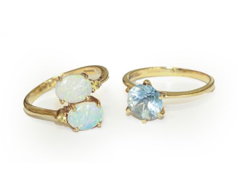 A 9 carat gold opal twist ring, finger size N, and a 9 carat gold blue zircon ring, finger size N1/2.  Opal ring - In good co