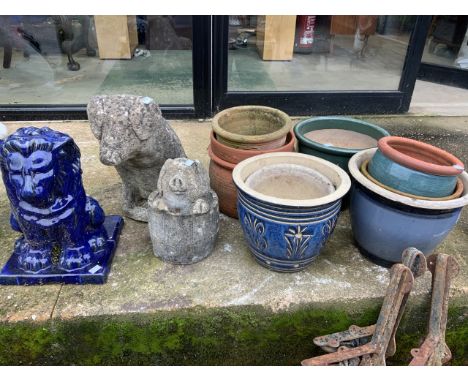 A blue glazed ceramic lion, two concrete pigs and a selection of pots. 