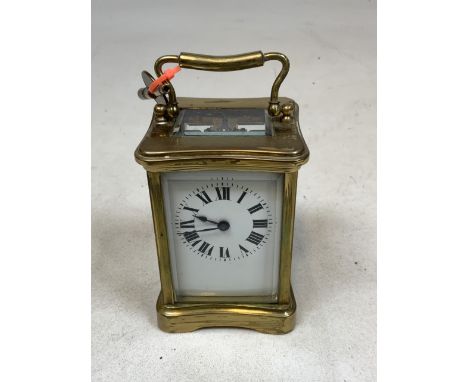 A french brass carriage clock with bevelled glass and white enamel face, with key. 