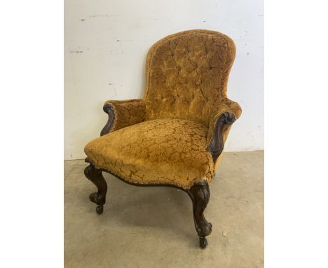 A Victorian carved upholstered button back chair. With later castors. Seat height H:44cm