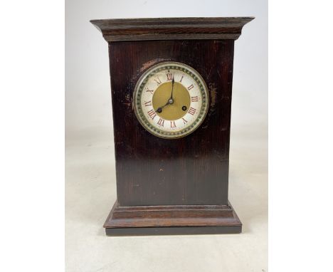 An oak cased mantle clock with enamel painted face. W:27cm x D:18.5cm x H:38cm