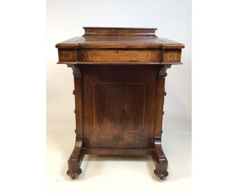 A Victorian inlaid davenport on ceramic castors. Leather writing slope to interior drawers lift up lid to ink and pen storage