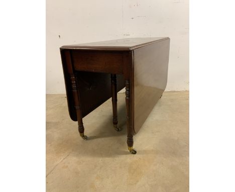 A Victorian mahogany gate leg table with brass castors on turned legs with double drop flaps.W:49cm x D:113cm x H:71cmExtende