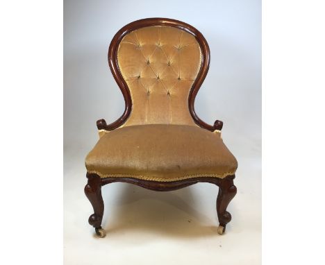 A Victorian upholstered button backed bedroom chair with metal and ceramic castors. Seat height H:40cm